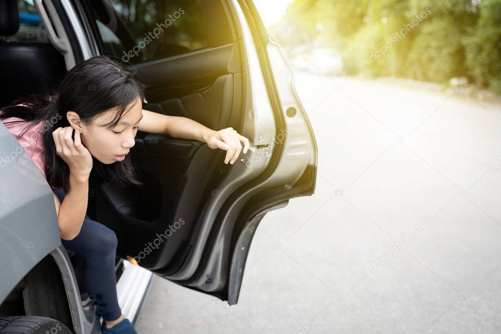 Unhappy asian child girl about to throw up from car sick or indigestion,female teenage vomiting in a car suffers from motion sickness or food poisoning,sad woman feel dizzy and nauseous from carsick