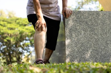 Close-up of legs of injured senior woman have knee pain,swollen knees and hand to massage the knee while walking,old people suffer from gout,arthritis,osteoarthritis,rheumatism,disease of the elderly 