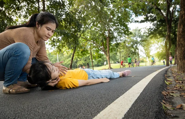 Doente filha é desmaiada e caiu no chão, mãe asiática ajuda, cuidar, adolescente exausta com insolação, alta temperatura, inconsciente feminino caiu no chão sofrem de queimadura solar muito quente  , — Fotografia de Stock