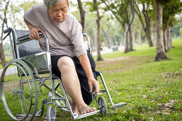 アジアのシニア女性の手は爪のクリップを保持し、高齢者の困難、骨、筋肉や関節の問題でペディキュアに到達するのに苦労し、爪をトリマーするために到達または下に曲げることが不可能になります — ストック写真