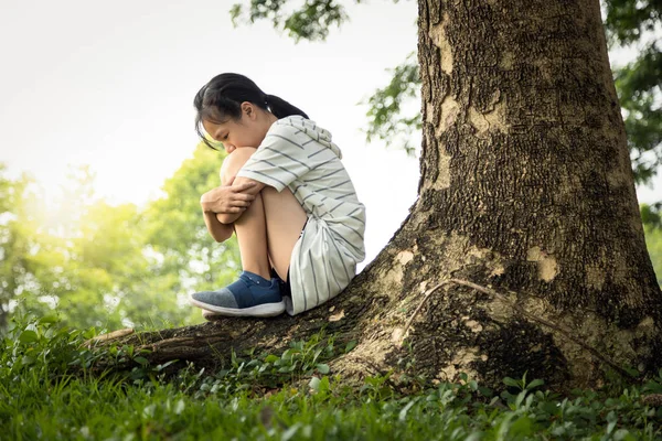 Depressed asian child girl was sitting alone crying and thinking about problems  at park,sad female teenage having psychological trouble with depressive symptoms feel despair suffering from depression — Stockfoto