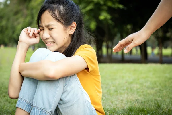 La main de la femme désireuse tend la main pour prendre soin, aider une fille perdue, les gens asiatiques tristes s'asseoir et pleurer, se perdre ou s'éloigner de ses parents dans un parc de la ville, manquer leurs parents, le deuil, le désespoir, la douleur — Photo