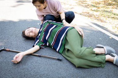 Sick asian senior woman or mother is fainted and fallen on  floor,daughter help,care,support of her,elderly people unconscious lying on the ground,concept of dizziness,fainting,losing consciousness  clipart