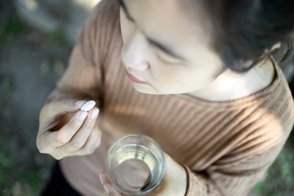 Enfermo asiático mujer celebración píldora y vaso de agua dulce en la mano, s —  Fotos de Stock