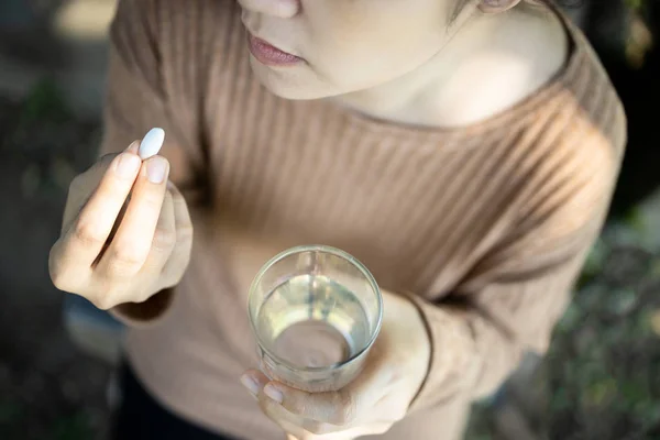 Stressad asiatisk ung kvinna hålla piller och glas vatten i handen, sorgliga kvinnliga människor som är sjuka av depression tar medicin antidepressiva, deprimerad flicka känner sig orolig och uttråkad av att ta läkemedlet, — Stockfoto