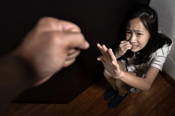 Niña asiática sentada en el suelo, mostrando señales de mano para detener, detener el abuso físico y la violencia doméstica, hombre o padre enojado levantó el puño de castigo, la hija está oprimida, el acoso escolar se siente temerosa, llorando —  Fotos de Stock