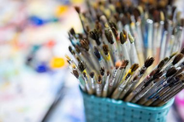 Okuldaki resim fırçaları, kullanılmış bir fırçada suluboya boya lekeleri, çocuklar onları sanat yaratımı, öğrenme ve geliştirme kavramları için kullandıktan sonra boya fırçaları.