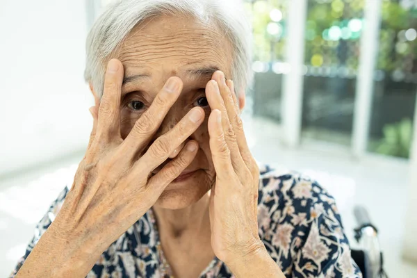 Asijská starší žena zírá skrz prsty, vyděšená zakrývající si tvář rukama, stydlivý, žena starší šmírování pocit strachu, strach nebo staří lidé se sociální fóbií skrývá její tvář — Stock fotografie