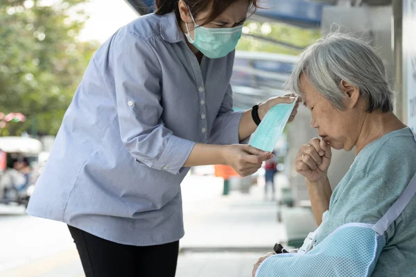 Дочка азіатської жінки доглядає, допомагає, носить захист маски для старшої матері, жінки і людей похилого віку з медичною маскою через забруднення повітря, поширення мікробів, коронавірусу, вірусу Вухана Корони 2019-ncov — стокове фото