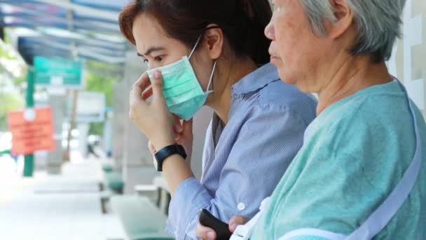 咳や発熱を伴う病気の女性高齢者のため 高齢者のための医療面マスクを身に着けているアジアの女性 バス停で他の人に細菌の拡散を防ぐ コロナウイルス Covid — ストック動画
