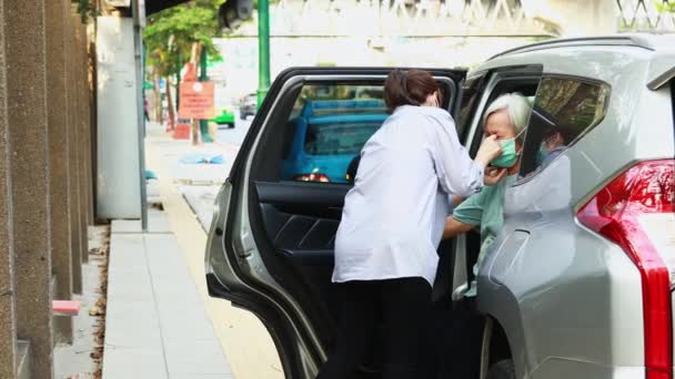亚洲女人则是关心 为老年人戴口罩保护老年人 同时下车来防止病毒在空气中传播 担心空气污染 恶劣的环境 — 图库视频影像