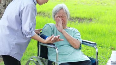 Injured asian senior woman wearing elbow support suffering from sore muscle,elbow joint arm pain,female caregiver do not intend to massage hard,unhappy elderly with elbow protector pads feeling hurt