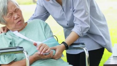 Injured asian senior woman wearing elbow support suffering from sore muscle,elbow joint arm pain,female caregiver do not intend to massage hard,unhappy elderly with elbow protector pads feeling hurt