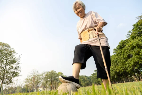 Щаслива азіатська старша жінка вправа втратила стільки ваги і відмінно здоровий з футбольним м'ячем, активна жінка похилого віку грає зі старим футболом, виглядає впевнено, охорона здоров'я, хороший здоровий спосіб життя — стокове фото