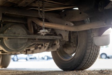 Arabanın altında depolanan yedek tekerlek çalınmış, yedek tekerlek kaybolmuş, araba lastiği kayıp, park yerinde çalıntı lastik, soygun sigortası, hırsızlık, hırsızlık, suç, keş sorunları...