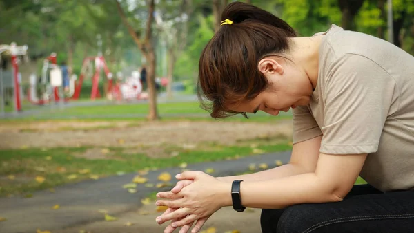 Trött asiatisk kvinna sitter ensam, ledsen, deprimerad, överväldigad kvinna i parken, känsla frustrerad, förvirrad, hopplös, finansiella, livsproblem, ekonomisk kris, familj disunit, stressad flicka arbetslös — Stockfoto
