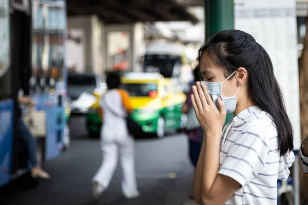Asian child girl suffer from cough,sneeze with protection mask,sick woman wearing medical mask to prevent air pollution in the city,girl with face mask,concept of pollution,dust allergies,bad health