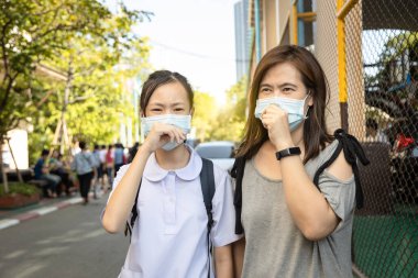 Kamuya açık alanda tıbbi maske takan Asyalı kız çocuğu, sokaklarda maske takanlar, enfeksiyonun Covid-19 'un yayılmasını önlüyor, grip virüsü, Coronavirus' un korunması, Covid-19 salgını