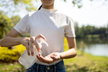 Asyalı kız çocuğu alkol antiseptik jeli kullanıyor, önleme, sık sık el temizleme, Covid-19 salgını enfeksiyonunu önleme, el dezenfektanı ile el yıkama, Corona virüsü bulaşmasını önleme.