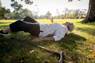 Senior woman was lying on the ground because slipped down and fell,walking alone at park,elderly is trying to raise their hand and ask for help,old people fell to the floor during exercise,health care clipart