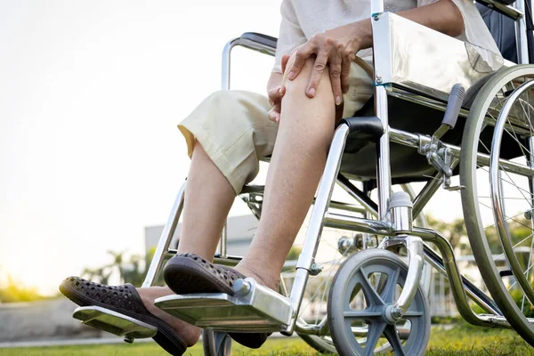 足の膝の痛みと手が膝を保持するために車椅子に座っているアジアのシニア女性 急性膝関節痛を持つ高齢者 骨の問題 身体的損傷 高齢者は関節炎に苦しむ リウマチ — ストック写真
