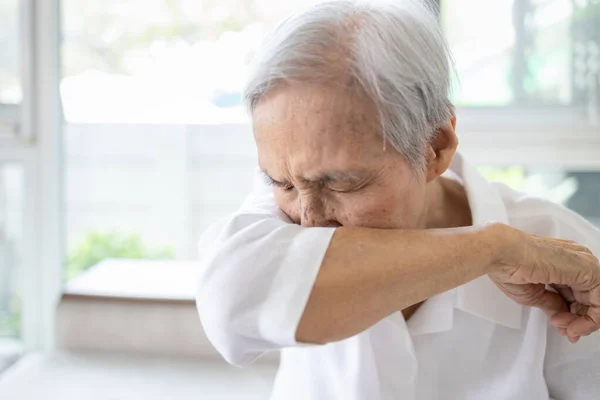 亚洲老年人打喷嚏 咳嗽在袖子或肘部以防止Covid Corona病毒的传播 生病的老年妇女感染了流感 高烧笼罩鼻子 手臂因灰尘 空气污染 过敏而流口水 — 图库照片