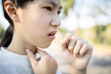 Sick asian woman has a chronic cough with tonsillitis,ill child girl touch the neck with fever,acute cough,sore throat pain irritation,voice is hoarse from cold,influenza, respiratory tract infection clipart