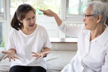 Kızgın yaşlı insanlar evde agresif bir kadınla şiddetli bir şekilde tartışıyor, yaşlı anne kızını işaret ediyor, tartışıyor, birbirine bağırıyor, nankör, kötü ilişkiler, aile içi çatışma konsepti