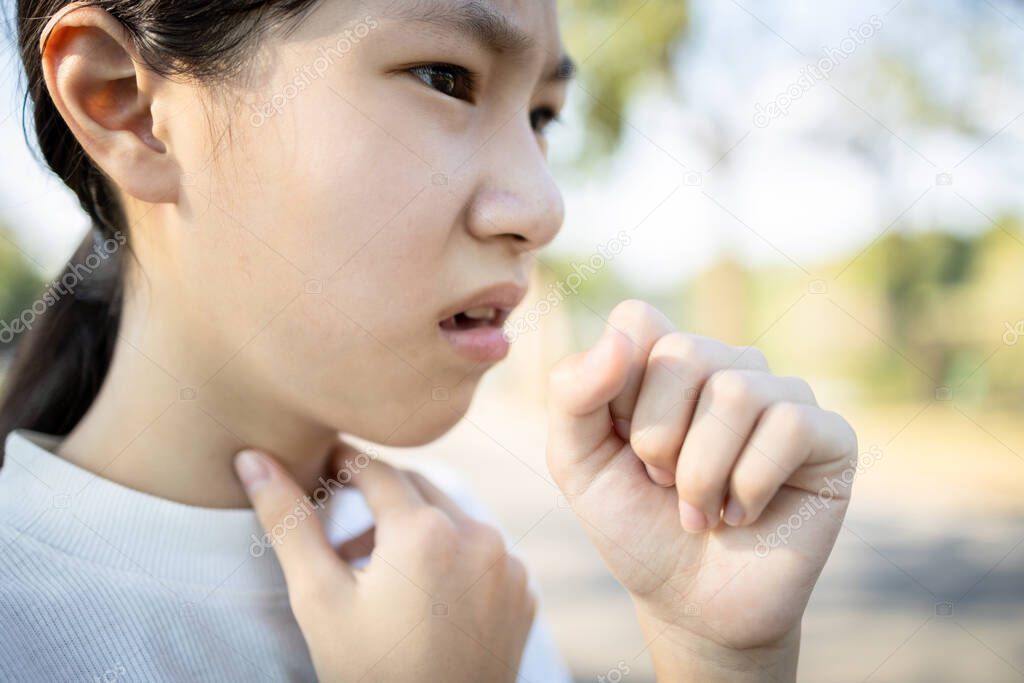 Sick asian woman has a chronic cough with tonsillitis,ill child girl touch the neck with fever,acute cough,sore throat pain irritation,voice is hoarse from cold,influenza, respiratory tract infection
