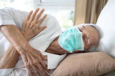 Maske takan son sınıf hasta kadının ateşi, titremesi, ateşi, üşütmesi, üşütmesi, üşütmesi, vücudunun her yerinde kas ağrısı, ateşi, Coronavirus enfeksiyonu olan yaşlı bir hastası var.