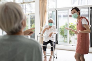 Yaşlı, yaşlı kadın ve kız çocuklarının aileleri mesafeyi koruyarak, grip, Coronavirüs, Covid-19 salgını, koruyucu maskeli insanlar, güvenlik için sosyal mesafeyi koruyarak konuşuyorlar.