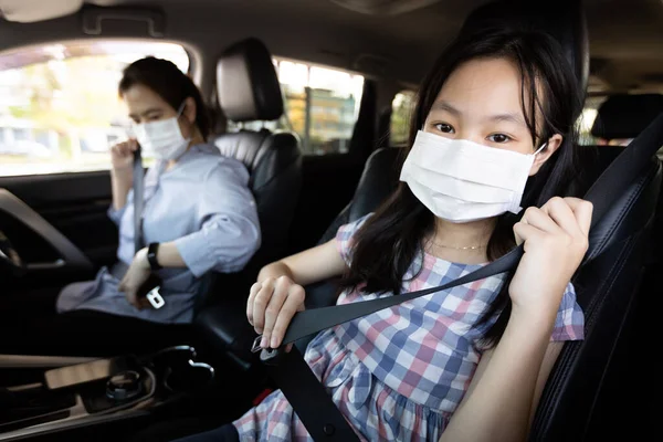 안전띠를 어머니와 운전을 안전벨트를 코로나 바이러스가 유행하는 보호용 마스크를 착용하고 — 스톡 사진