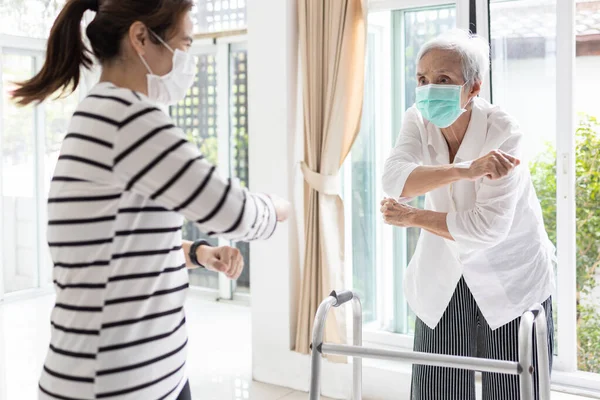 Asyalı kadın, Covid-19, Coronavirus salgını sırasında evde kalıp evden sağlık hizmetleri için spor yapan yaşlı, yaşlı anne ve kız çocukları için egzersiz yapıyor.