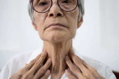 Close up of female neck,asian senior woman thyroid gland control,old elderly was touching the neck,checking thyroid gland with her hands,concept of thyroid disorder,sore throat,dysphagia,tonsillitis clipart