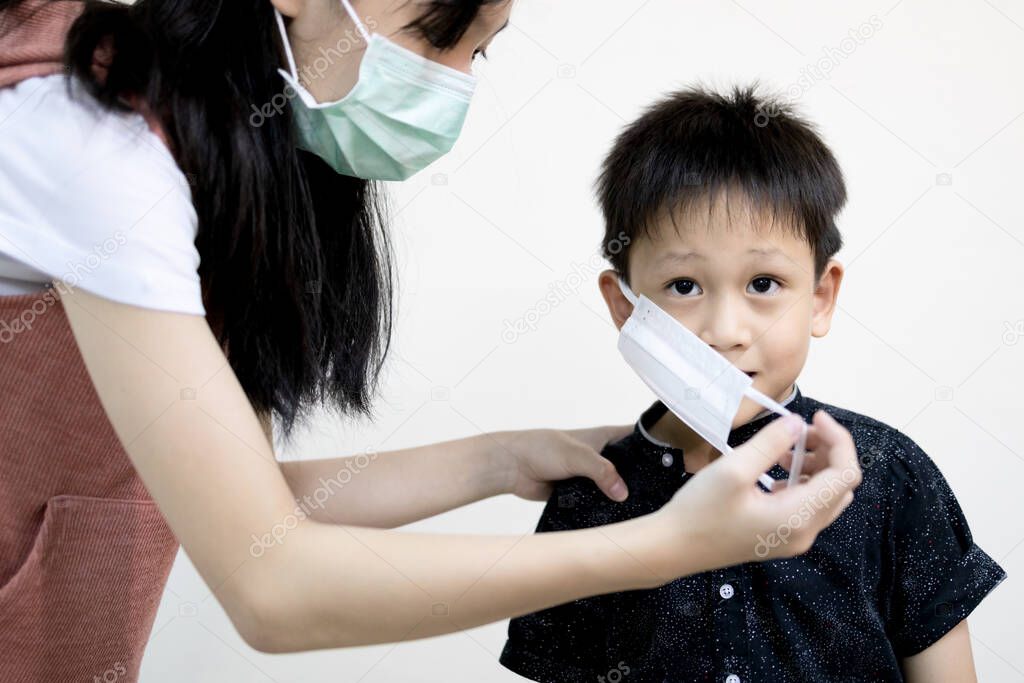 Asian child girl in face mask,Big sister is wearing protective mask to prevent contagious disease with her little brother, kid boy at risk of infection from pandemic of the Coronavirus or Covid-19