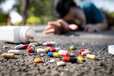 Sick asian man have any chronic health conditions,heart attack lying on the floor after falling down,male people trying to reach for a bottle of medicine,lot of pills at the street,medical emergency clipart