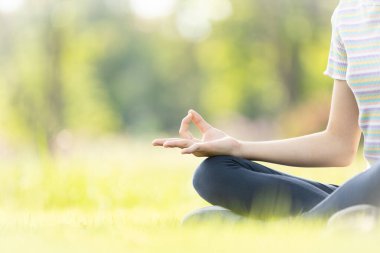 Kadın el meditasyonu yoga pozu veya nilüfer çiçeği pozisyonu, doğa parkında yoga meditasyonu yapan kız çocuğu, rahatlama, sakinlik, doğada meditasyon, sağlık konsepti 