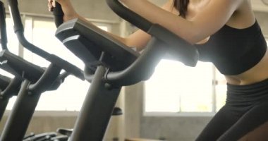 Durağan bisikletli çekici Asyalı kadın jimnastik salonunda dönüyor. Ağır çekim. Sağlık, Egzersiz ve Spor Konsepti.