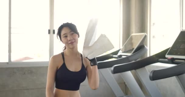 スローモーションで体育館に入る美しいアジアの女性のフォローアップショット 彼女は自信を持ってポニーテールを引っ張る — ストック動画