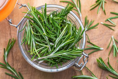 Taze kesilmiş yeşil biberiye yaprakları (Rosmarinus officinalis). Kırsal ve ahşap görünümlü. Akdeniz mutfağının içeriği ve iyileştirme amaçlı ev yapımı.