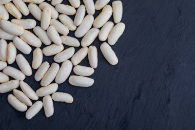 Beyaz fasulye (fabes) ham (baklagil) siyah arkaplanda doku ile birlikte. Metninizi buraya eklemek için boşluk ile.