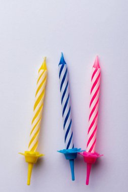 Beyaz arka planda 3 doğum günü mumu. Doğum günü tebrik kartı için. Metin eklemek için boşluk. Çok renkli, mavi, kırmızı, sarı ve beyaz. Doğum günü tebrik kartı için..