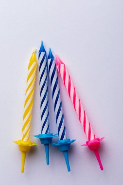 Beyaz arka planda 4 doğum günü mumu. Doğum günü tebrik kartı için. Metin eklemek için boşluk. Çok renkli, mavi, kırmızı, sarı ve beyaz. Doğum günü tebrik kartı için..