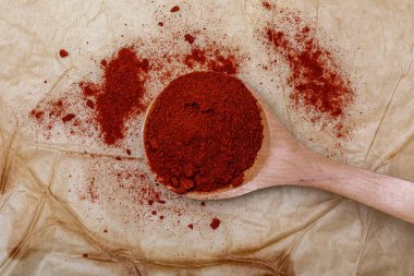 Tahta kaşıkta kırmızı biber (baharat koleksiyonu). Kırsal arkaplanda.