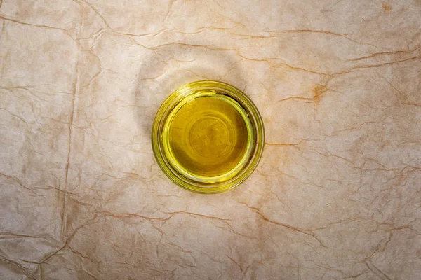 Extra virgin olive oil in glass bowl. Rustic Background. Top view. — Stock Photo, Image
