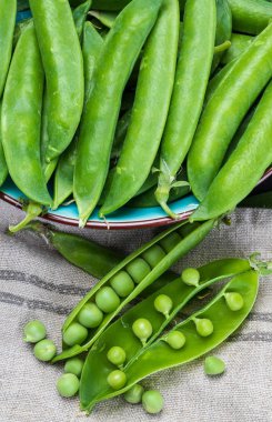 Yeşil, yumuşak, taze ve çiğ bezelye. Yakın çekim ve üst görünüm. Rustik