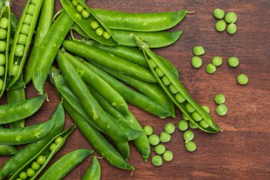 Yeşil, yumuşak, taze ve çiğ bezelye. Yakın çekim ve üst görünüm. Rustik görünüş. Rustik görünüş. Siyah arka plan.