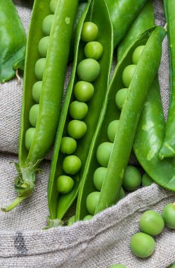 Yeşil, yumuşak, taze ve çiğ bezelye. Yakın çekim ve üst görünüm. Rustik görünüş. Rustik görünüş. Siyah arka plan.