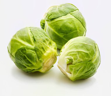 Çiğ, taze ve bütün Brüksel lahanası (lahanalar - Brassica oleracea) yakın çekim. Beyaz arkaplanda izole.