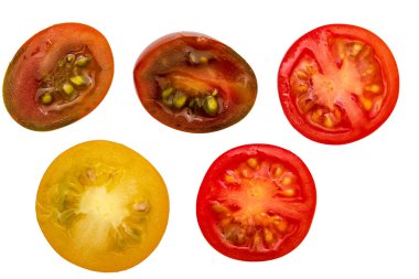 Taze ve çiğ kiraz domatesleri (kırmızı, kestane rengi ve sarı), ikiye bölünmüştür. Beyaz arkaplanda su damlaları izole edilmiş